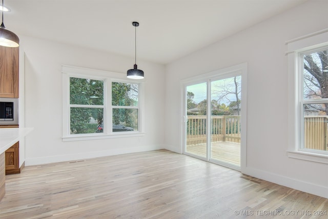 unfurnished dining area with light wood-type flooring