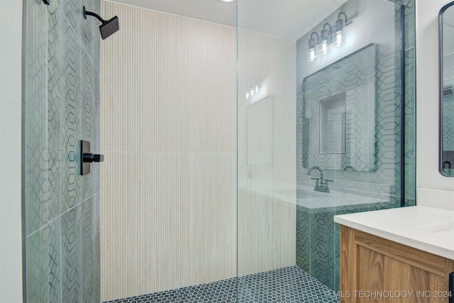 bathroom with vanity, tiled shower, and tile walls