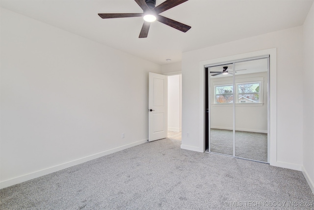 unfurnished bedroom featuring ceiling fan, a closet, and light carpet