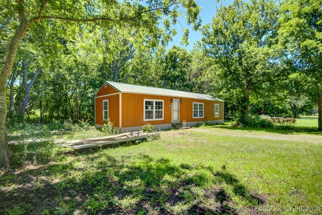 ranch-style house featuring metal roof and a front lawn