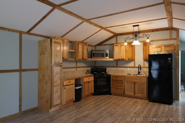 kitchen featuring vaulted ceiling, black appliances, a sink, and light wood-style floors