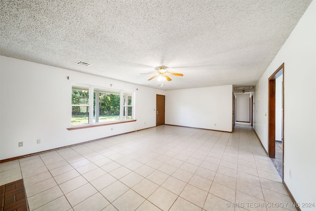 tiled spare room featuring a textured ceiling and ceiling fan