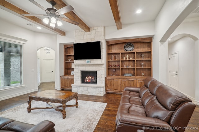 living room featuring a fireplace, beam ceiling, dark hardwood / wood-style floors, and ceiling fan