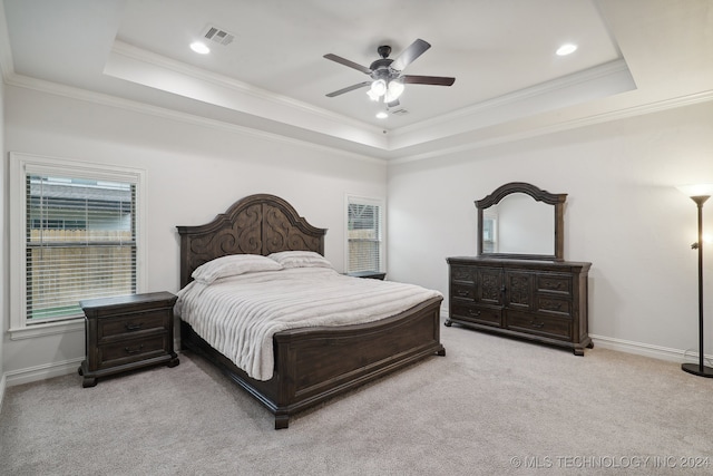 bedroom with a raised ceiling, ceiling fan, and light colored carpet