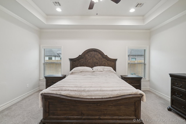 bedroom with ceiling fan, a raised ceiling, crown molding, and light carpet