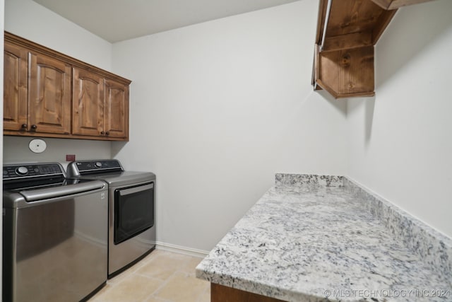 laundry area with cabinets and washing machine and clothes dryer