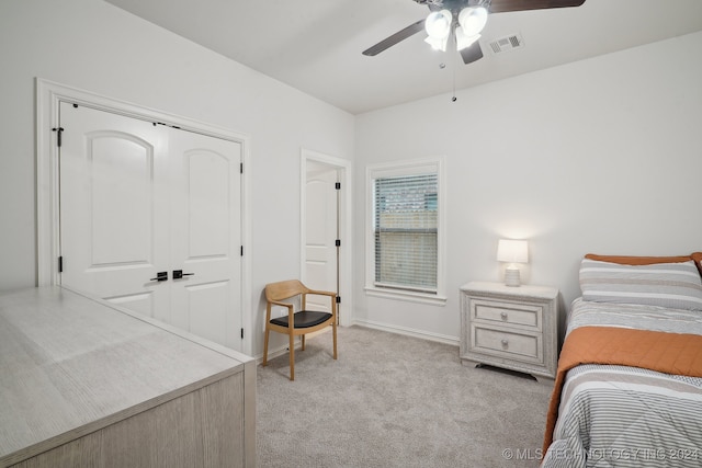 bedroom with a closet, ceiling fan, and light colored carpet