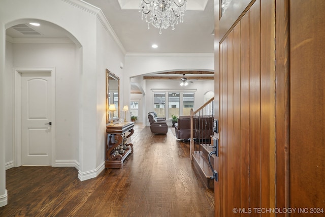 foyer featuring dark wood-type flooring, ceiling fan with notable chandelier, and ornamental molding