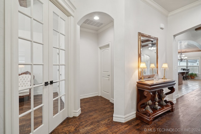 hall featuring a chandelier, french doors, dark wood-type flooring, and ornamental molding