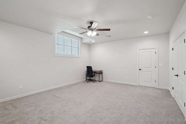 unfurnished office featuring light carpet and ceiling fan