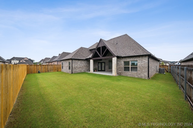 back of house featuring a lawn, a patio, and central AC unit