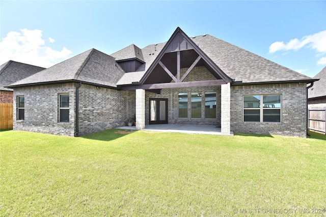 back of house featuring a lawn and a patio area