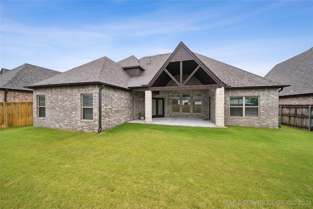 back of house with a patio area and a lawn