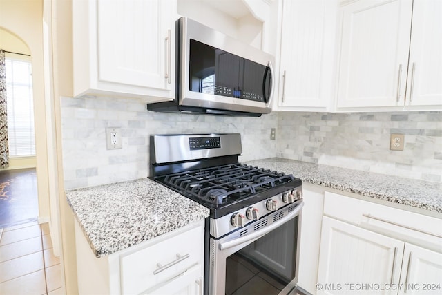 kitchen featuring white cabinets, stainless steel appliances, and tasteful backsplash