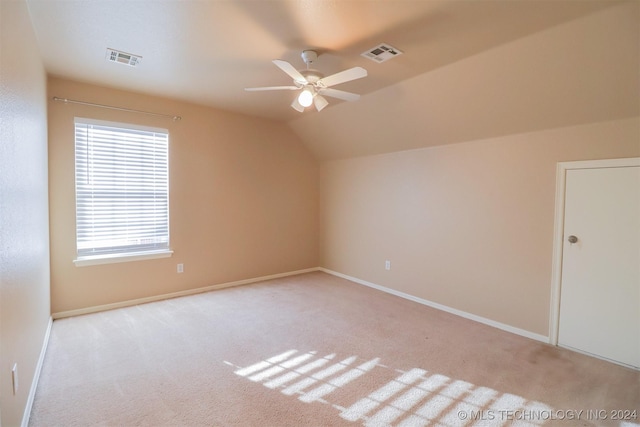 additional living space featuring light colored carpet, vaulted ceiling, and ceiling fan