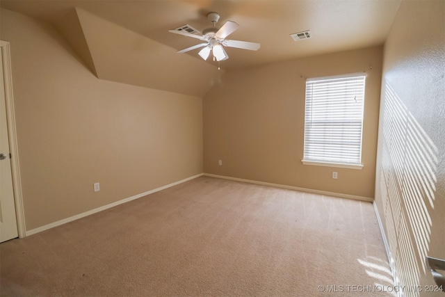 additional living space with ceiling fan, light colored carpet, and vaulted ceiling