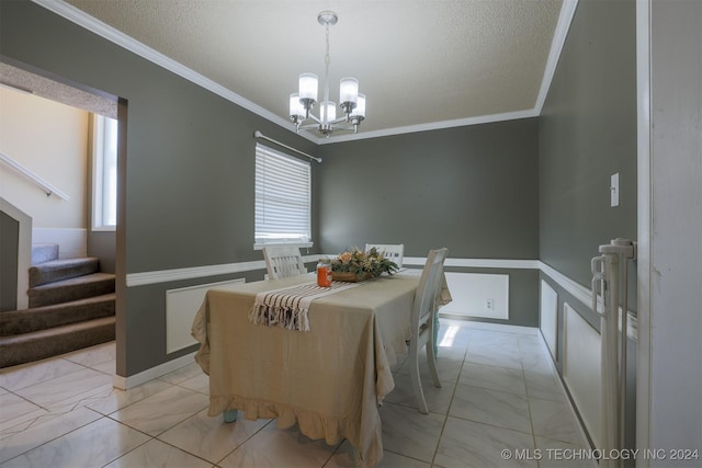 dining room with a chandelier, a textured ceiling, and crown molding