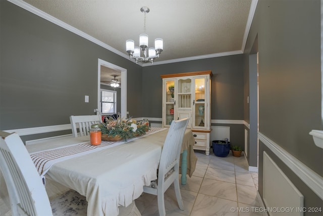 dining space with ceiling fan with notable chandelier, a textured ceiling, and crown molding