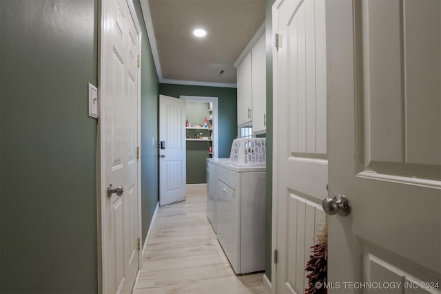 clothes washing area featuring cabinets, light wood-type flooring, independent washer and dryer, and ornamental molding