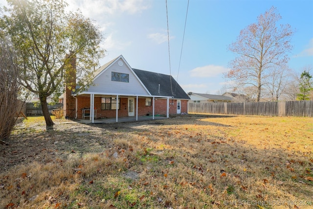 back of house with a lawn and a patio area