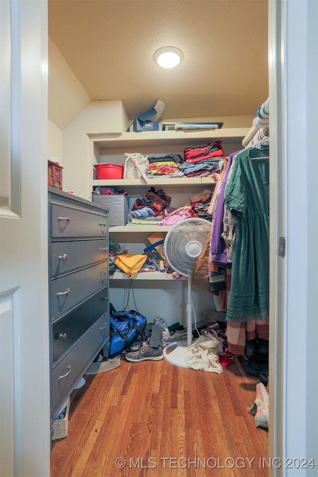 spacious closet with wood-type flooring and vaulted ceiling