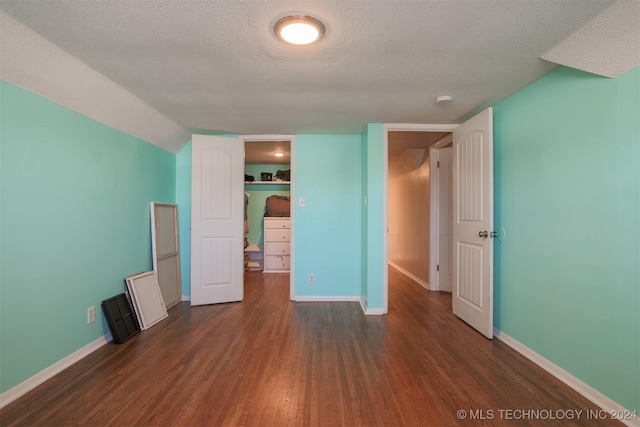 unfurnished bedroom with dark hardwood / wood-style flooring, a textured ceiling, and a closet