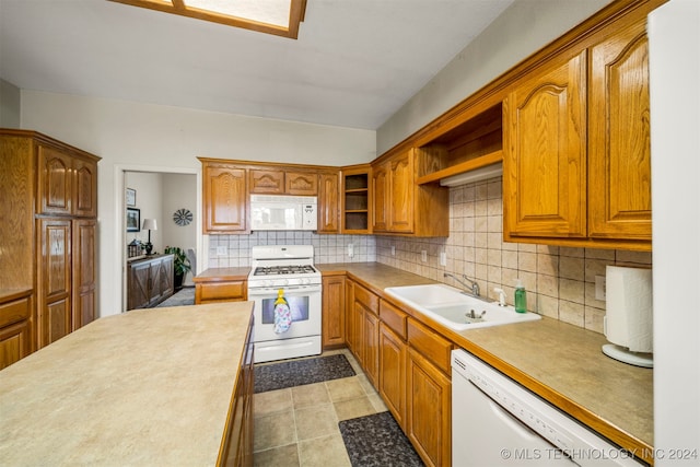 kitchen with tasteful backsplash, sink, and white appliances