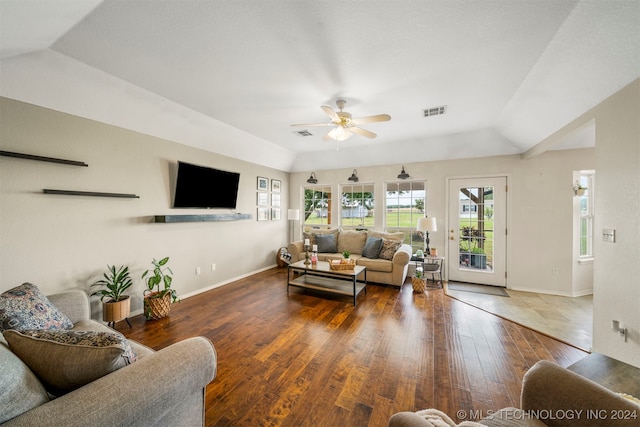 living room with dark hardwood / wood-style flooring, vaulted ceiling, and ceiling fan