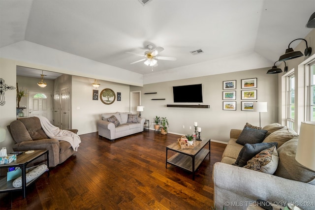 living room with a raised ceiling, ceiling fan, and dark hardwood / wood-style floors