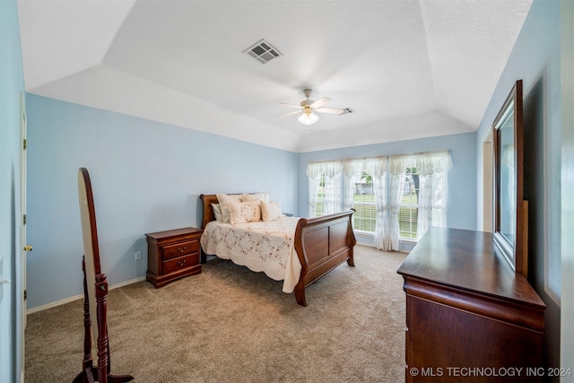 carpeted bedroom featuring ceiling fan and a tray ceiling