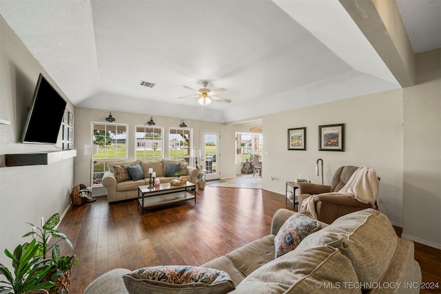 living room featuring ceiling fan, dark hardwood / wood-style floors, a textured ceiling, and a tray ceiling