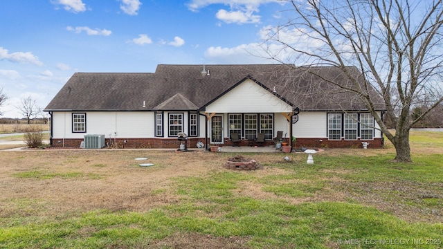 view of front of home featuring central AC unit, a patio, an outdoor fire pit, and a front yard