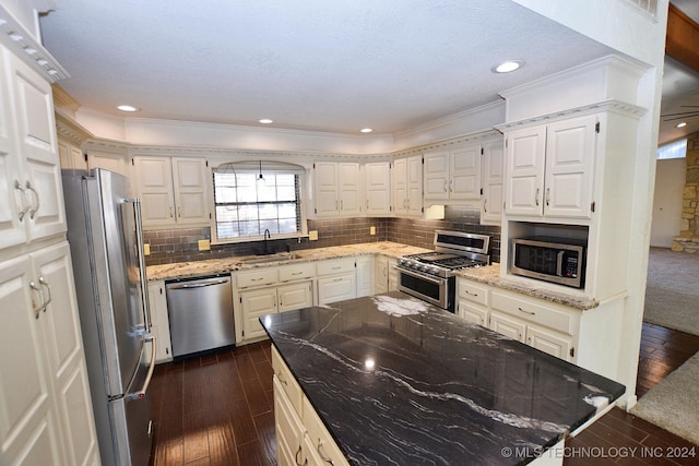 kitchen featuring light stone countertops, dark wood-type flooring, crown molding, white cabinets, and appliances with stainless steel finishes