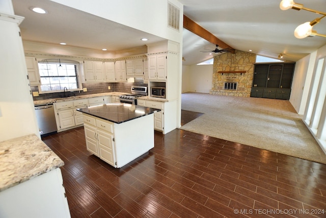 kitchen featuring a center island, vaulted ceiling with beams, decorative backsplash, dark hardwood / wood-style flooring, and stainless steel appliances