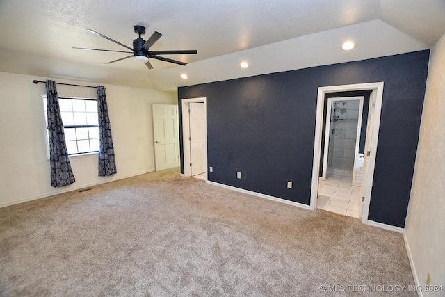 spare room featuring light colored carpet, ceiling fan, and lofted ceiling