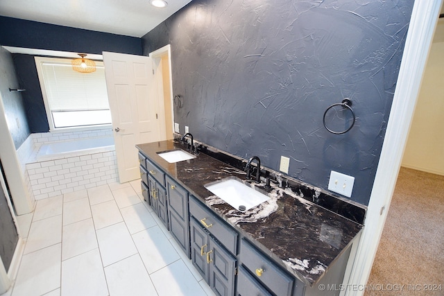 bathroom with tile patterned flooring, vanity, and a relaxing tiled tub