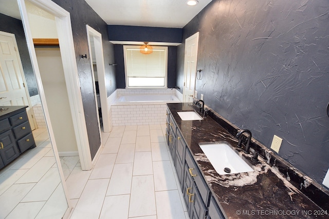 bathroom featuring a bathing tub, tile patterned flooring, and vanity