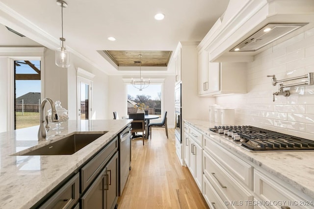 kitchen with light stone countertops, white cabinetry, sink, and stainless steel appliances