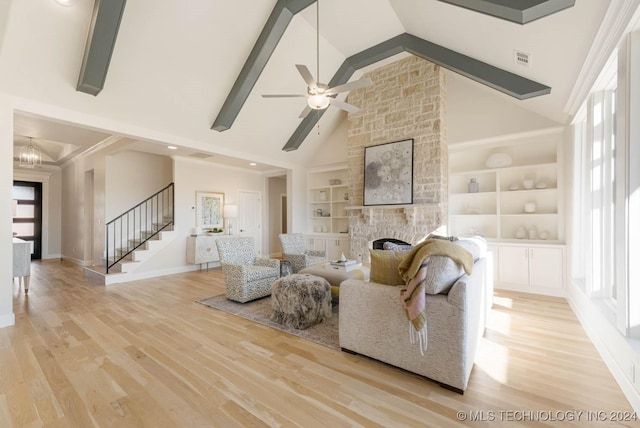 living room featuring light hardwood / wood-style flooring, high vaulted ceiling, built in features, a fireplace, and ceiling fan with notable chandelier