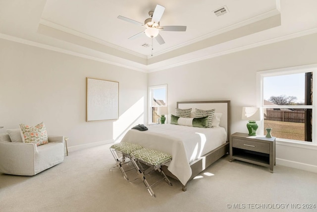 bedroom with carpet floors, a tray ceiling, ceiling fan, and crown molding