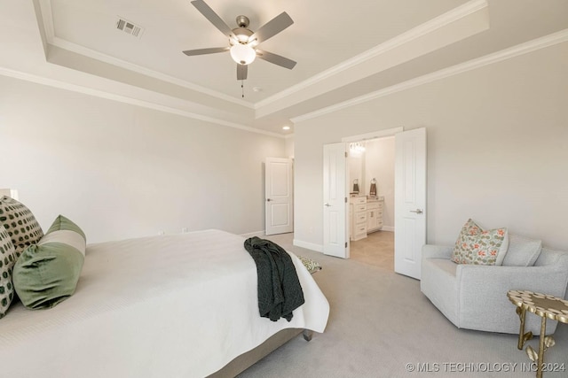 carpeted bedroom featuring a raised ceiling, connected bathroom, ceiling fan, and ornamental molding