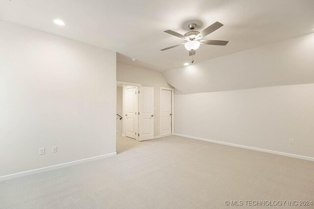 additional living space featuring light colored carpet, ceiling fan, and lofted ceiling