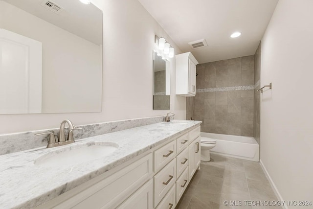 full bathroom with tile patterned floors, vanity, tiled shower / bath combo, and toilet