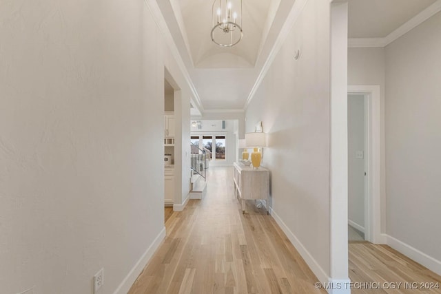 corridor featuring light hardwood / wood-style floors, a notable chandelier, and ornamental molding