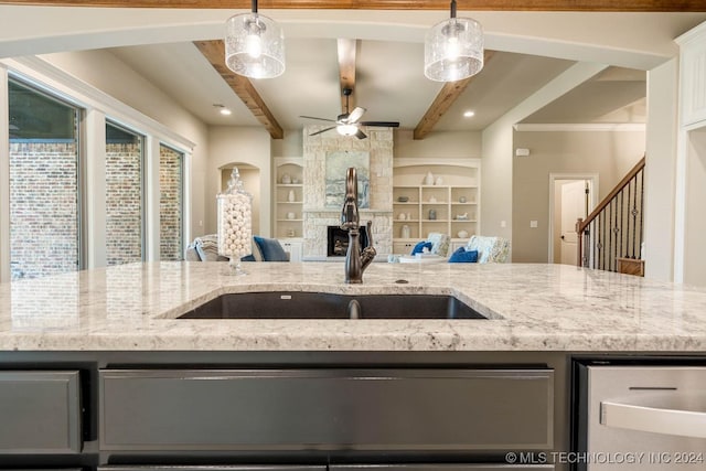 kitchen with ceiling fan, decorative light fixtures, beam ceiling, light stone counters, and white cabinetry