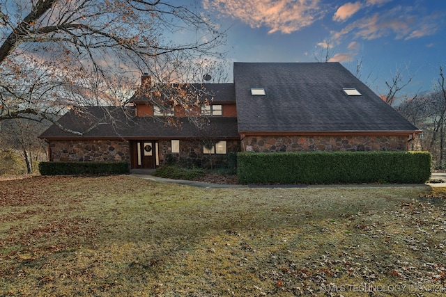 back house at dusk featuring a yard