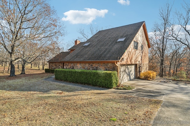 view of side of property featuring a lawn and a garage