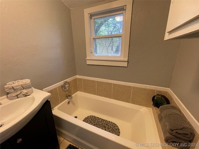 bathroom featuring a tub, tile patterned flooring, and vanity