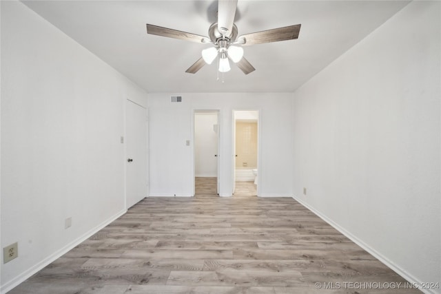 unfurnished bedroom with ensuite bath, ceiling fan, and light wood-type flooring