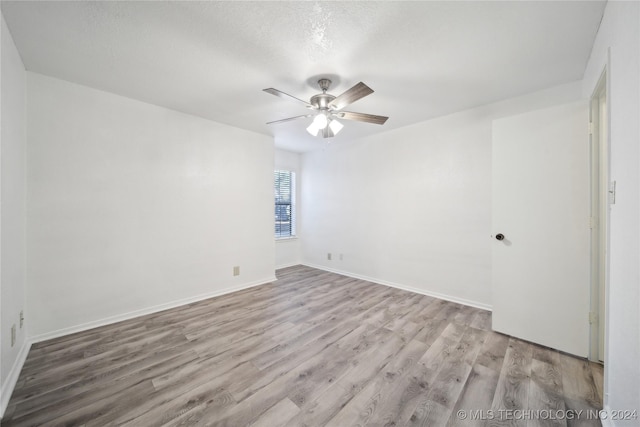 unfurnished room with a textured ceiling, light hardwood / wood-style floors, and ceiling fan